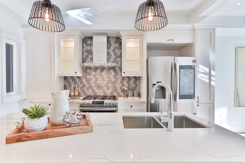 Modern white kitchen design featuring sleek cabinet knobs on shaker cabinets by HomeTouch.