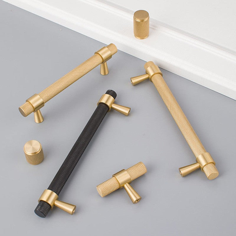 A Hometouch handle in brass with a black and gold contrast finish features a knob shape designed for cabinets and drawers, suitable for product photography on the brand's website.