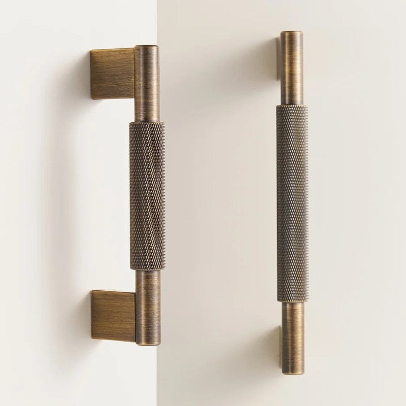 A brass door pull with a cross-shaped knurled handle, designed for cabinet or furniture use, is presented in a product photography style suitable for hardware catalogs or e-commerce on Hometouchware.com.