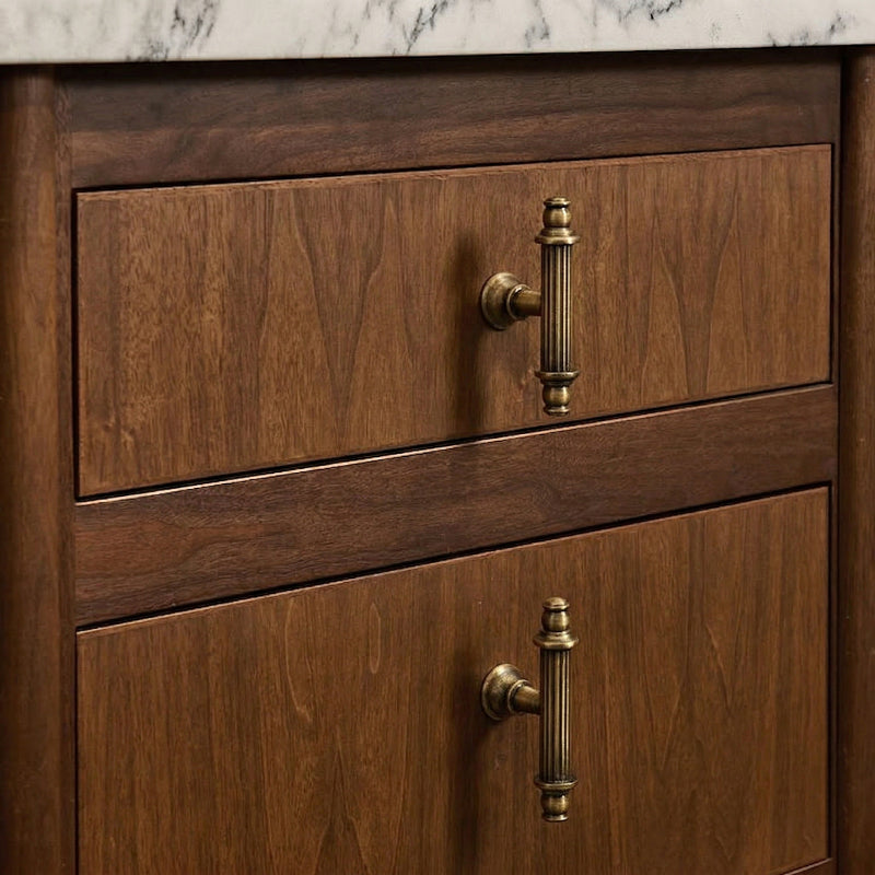 A brass cabinet pull with a gold finish features an elongated oval shape, designed for furniture and cabinetry hardware applications.