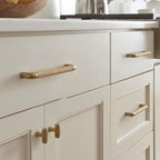 A teardrop-shaped cabinet pull in brass gold finish, designed for furniture hardware with a product URL linking to hometouchware.com.