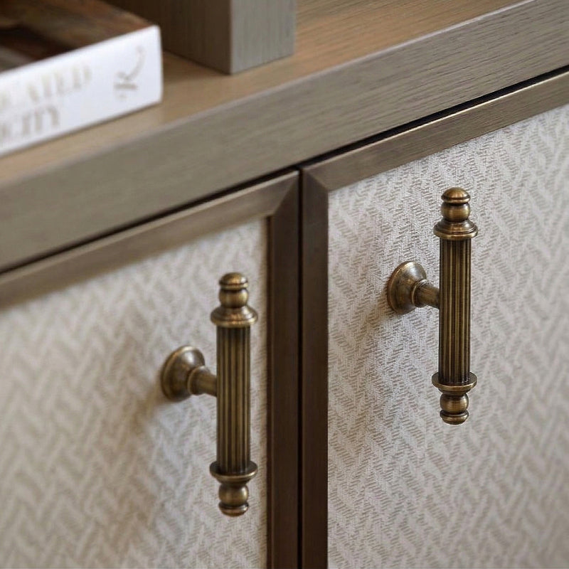 A brass cabinet pull with a teardrop-shaped handle in a gold finish, designed for furniture and cabinetry hardware applications.