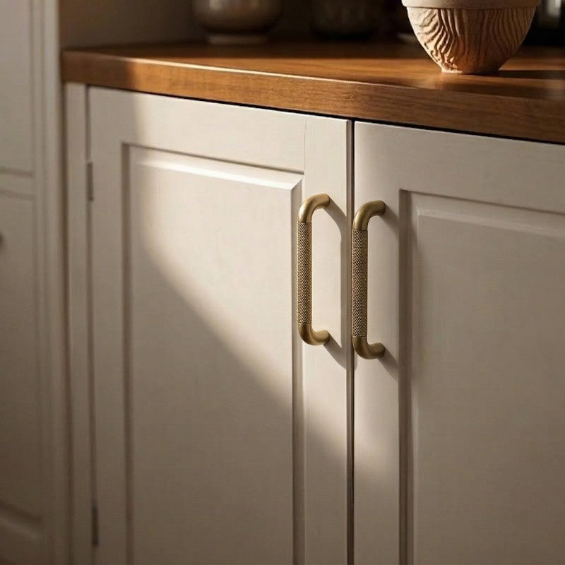 A teardrop-shaped brass cabinet pull in a gold finish, designed for furniture and cabinetry hardware applications, with product details available at www.hometouchware.com.