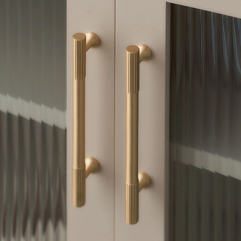 A polished brass cylindrical cabinet handle featuring knurled texture and Mid-Century Modern design from Hometouch, suitable for furniture hardware applications; product details available at www.hometouchware.com.