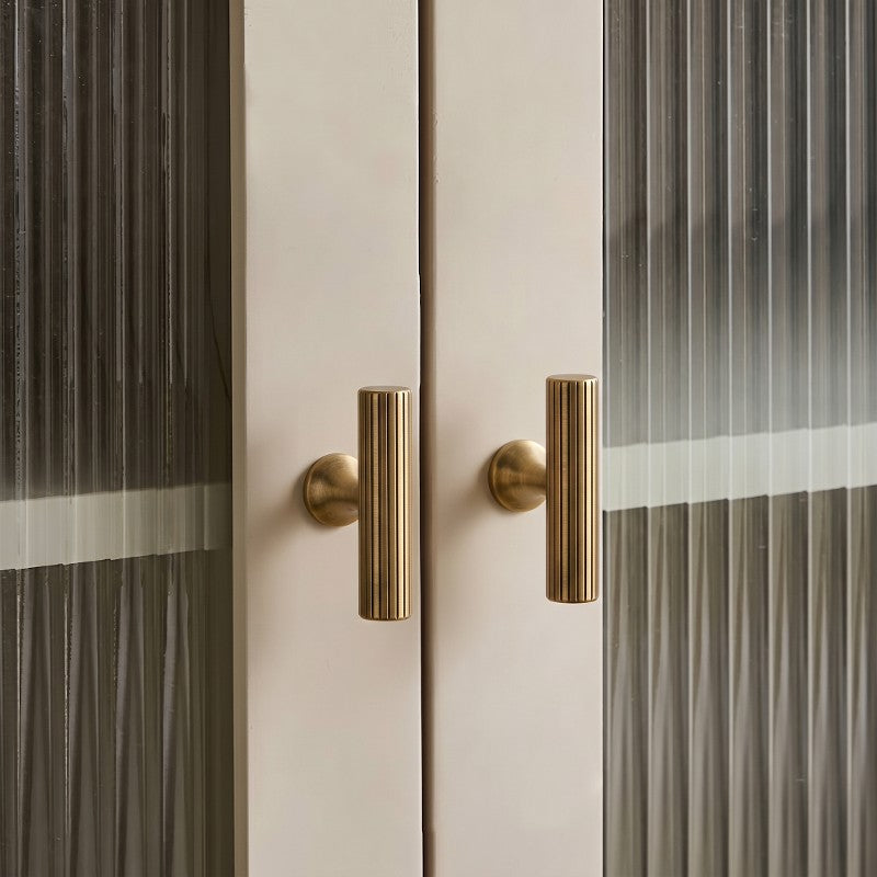 A Hometouch cabinet handle features a polished brass finish and bar-shaped design ideal for modern cabinet hardware installations.
