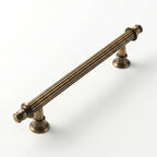 A Hometouch cabinet pull crafted in warm golden brass exhibits a curved profile ideal for modern kitchen and bathroom cabinetry hardware.