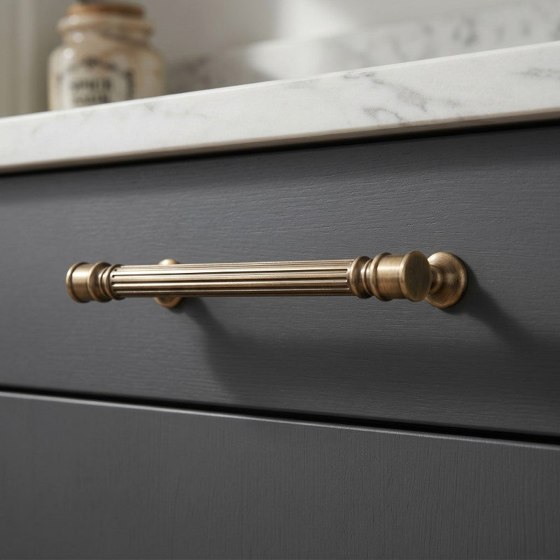 Hometouch's curved lever cabinet handle features an antique brass finish, designed for furniture and cabinetry installations requiring classic hardware with functional ergonomics.