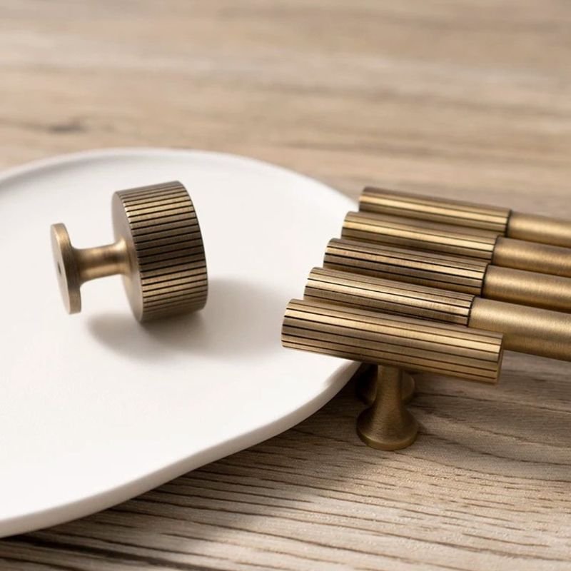Hometouch cabinet pull in antique brass finish features a knob-style bar design for furniture hardware applications, available at www.hometouchware.com.