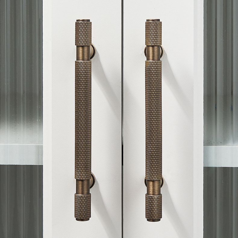 A solid brass Hometouch drawer pull features an antique brass finish and knurled cylindrical form designed for contemporary furniture hardware applications.
