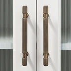 A solid brass Hometouch drawer pull features an antique brass finish and knurled cylindrical form designed for contemporary furniture hardware applications.