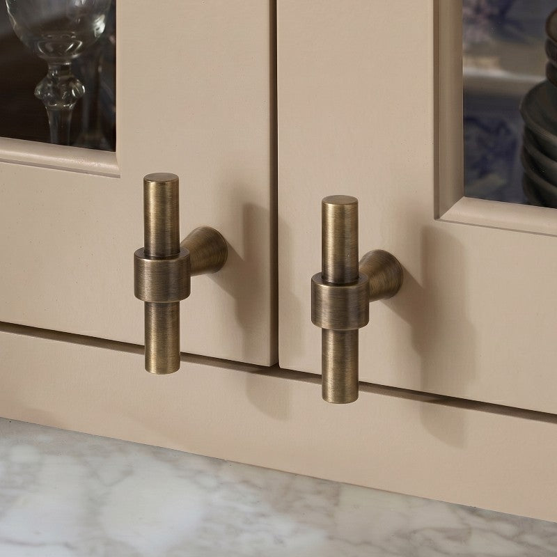 A solid brass cabinet pull with warm gold finish and ergonomic curved profile from Hometouch, designed for contemporary bar cabinetry installations requiring durable hardware with refined aesthetic appeal.