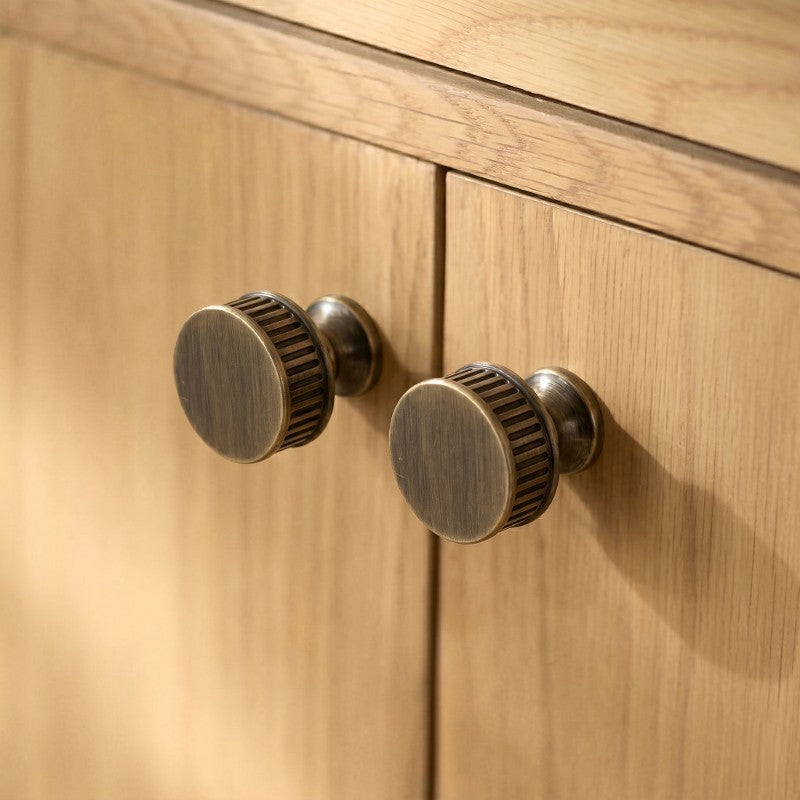 Textured, vintage-inspired cabinet knobs with subtle ridged detailing, ideal for warm wooden cabinetry—by HomeTouch.