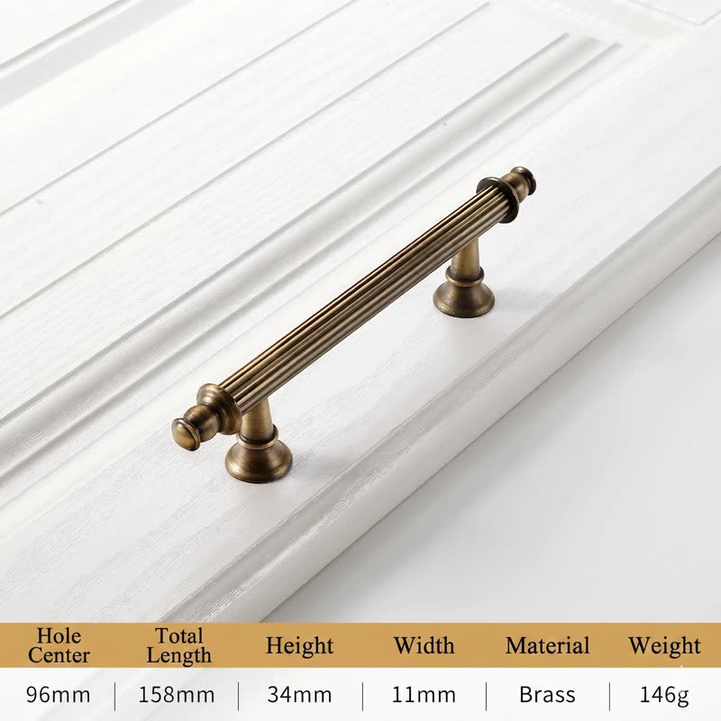 A textured, antique-style brass long bar pull with fluted detailing, designed as a vintage-inspired cabinet handle for classic kitchen or bathroom cabinetry by HomeTouch.