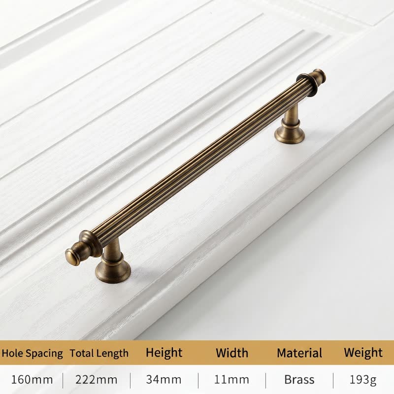 A textured, ornamental brass cabinet handle with fluted detailing and rounded finials, mounted on a white drawer front—ideal for modern European or Japandi-style kitchens and bathrooms by HomeTouch.